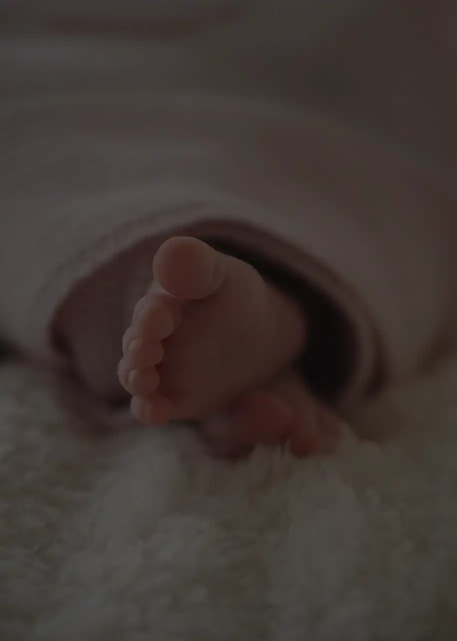 A newborn swaddled with feet out