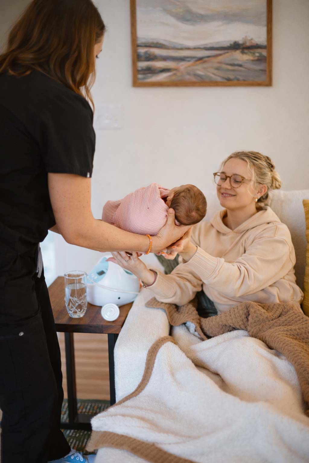 A parent resting with a newborn at home